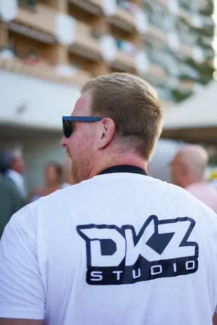 Espalda de la camiseta de DKZ Studio en un rodaje junto al mar · marketing y producción audiovisual para Águilas
