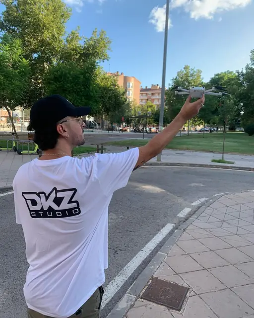 Operador de DKZ Studio pilotando un dron en una calle de ciudad para grabar vídeo aéreo · marketing y producción audiovisual para Águilas