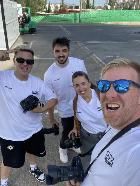 Cuatro miembros del equipo de DKZ Studio con cámaras en un evento deportivo al aire libre · agencia de marketing y vídeo para negocios de Guadalupe