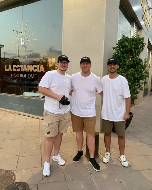 Tres miembros de DKZ Studio con camisetas blancas ante la fachada de un restaurante gastro · DKZ Studio, Murcia
