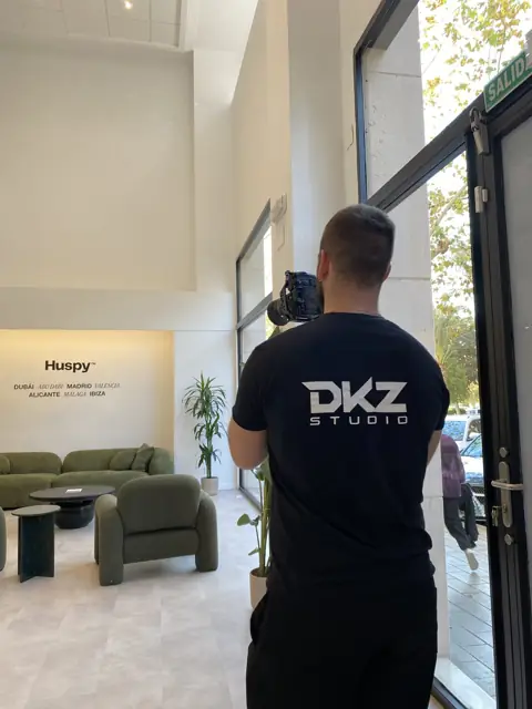 Videógrafo de DKZ Studio grabando en el interior de una oficina moderna con sofá y recepción · DKZ Studio, Murcia