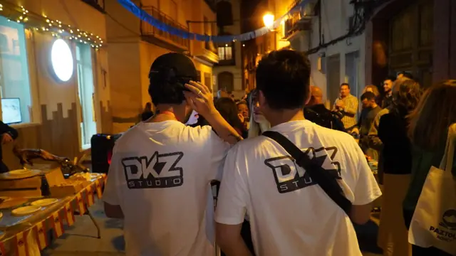 Dos miembros de DKZ Studio con camisetas del estudio grabando contenido en una calle concurrida de noche · DKZ Studio, Murcia