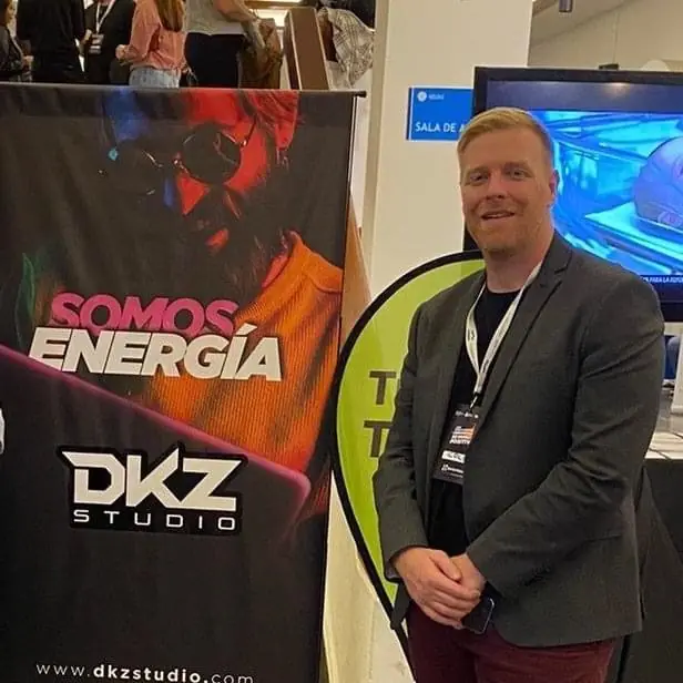 Speaker next to a DKZ Studio 'Somos energía' roll-up at a professional event · marketing and video agency for businesses in Sangonera la Verde