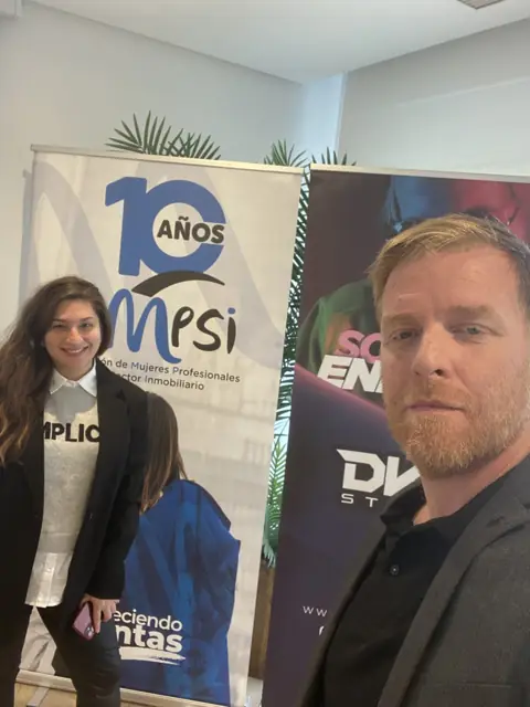 Two attendees take a selfie in front of the roll-up banners at a professional event with DKZ Studio · marketing and video agency for businesses in Sangonera la Verde