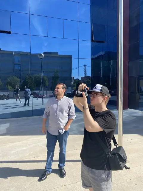 Videógrafo de DKZ Studio grabando a un directivo delante de un edificio de oficinas de cristal · marketing y producción audiovisual para Lorca